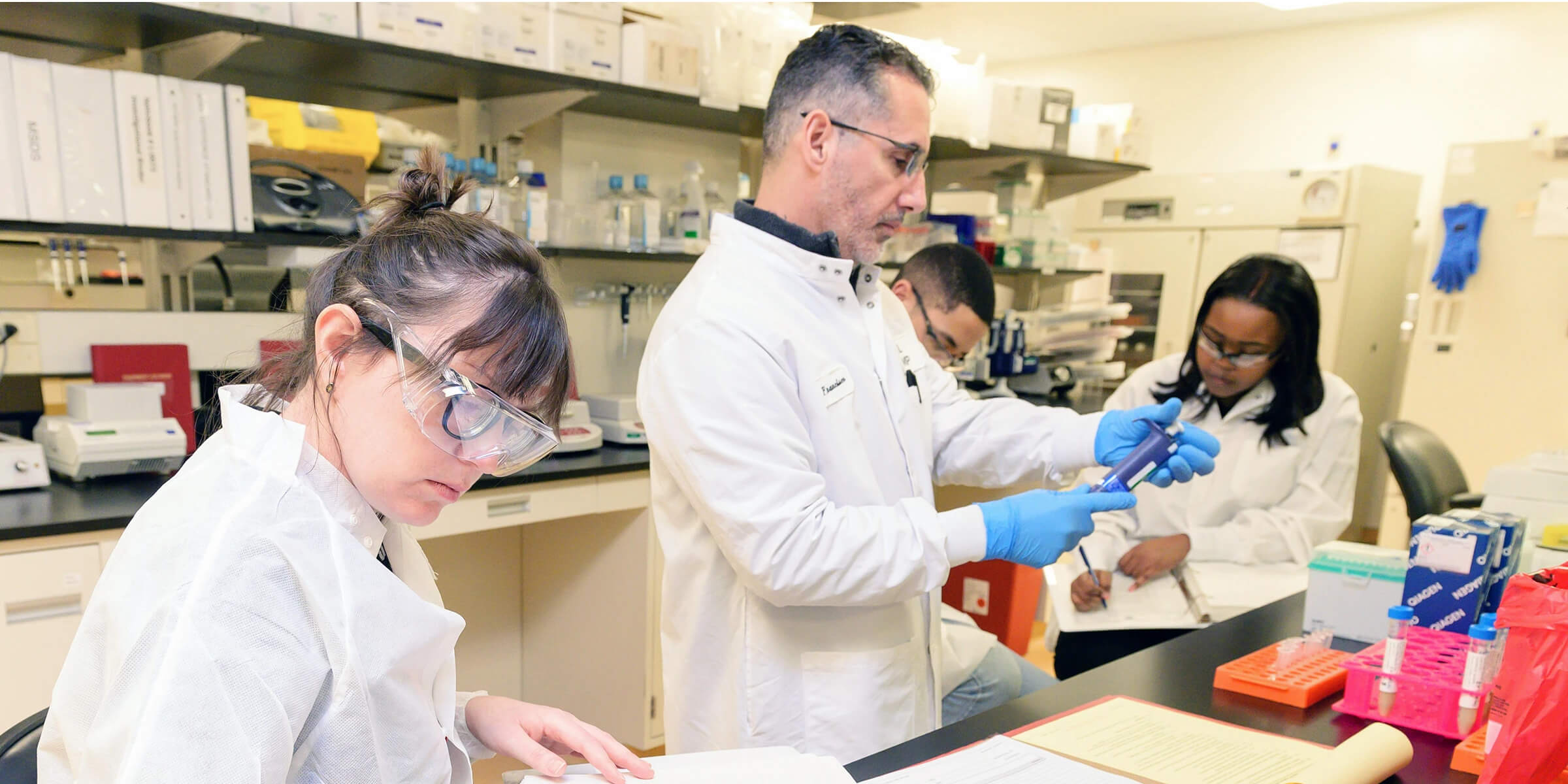 Researchers in a laboratory reviewing documents and handling samples